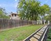 The other side yard is lined with a privacy wood fence while the fencing at the front of the yard is beautiful wrought iron connected to brick pillars. The paver pathway continues to a bonus tool storage shed. 