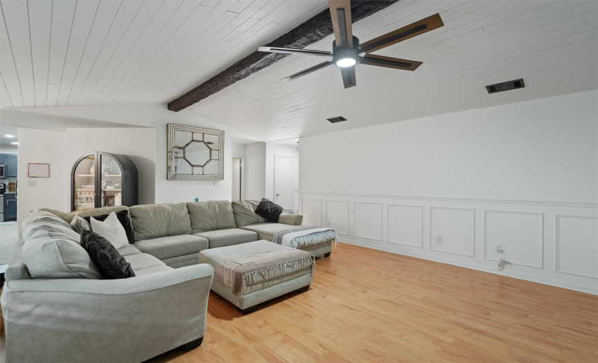A tastefully stained wood beam flows beautifully with the shiplap accents while an updated modern LED ceiling fan keeps the breeze flowing. 