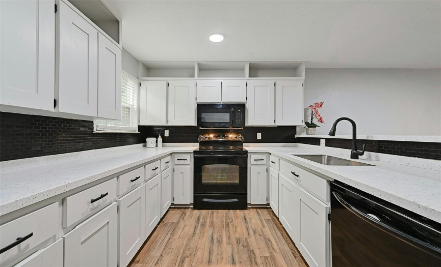 Adorned with the latest white shaker cabinets complemented by sleek black hardware, the kitchen boasts multiple upgrades.
