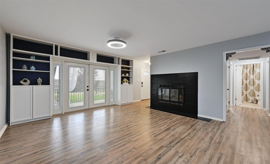 The spacious living room hosts a modern black tile fireplace as its centerpiece.