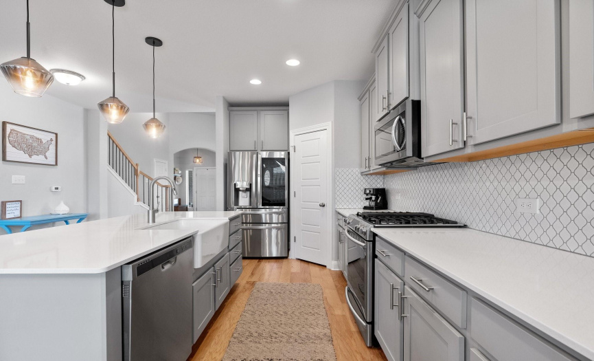 The kitchen is well-equipped with high-end stainless-steel appliances including a gas range. 
