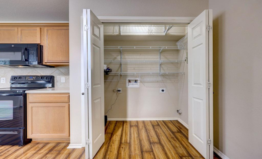The washer and dryer closet has a lot of shelving above