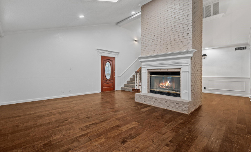 The star of the show is the impressive wood-burning fireplace, which features a lovely decorative wood mantelpiece that matches the stunning trim work around the front door and kitchen entryway. 