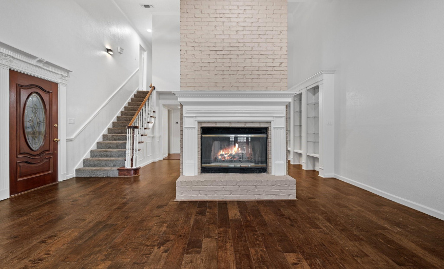 Step inside to discover soaring vaulted ceilings over the spacious living & dining rooms, which are separated by the centrally located wood-burning fireplace. 