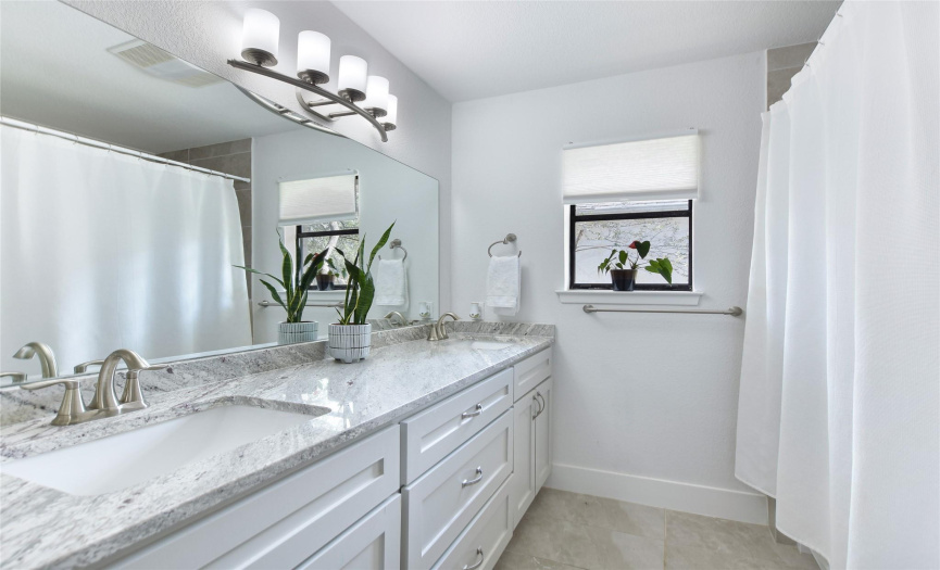 Well appointed guest bath with marble counter top and double vanity.
