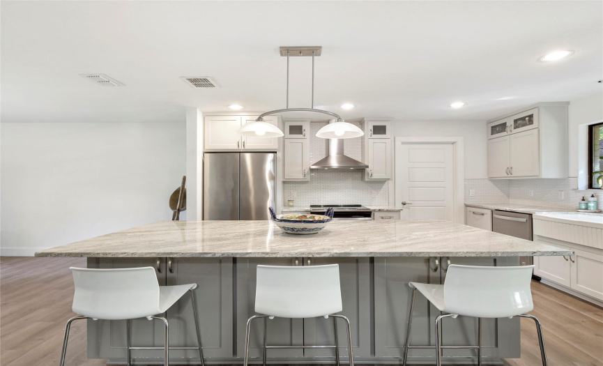 The kitchen has a large island with granite counter top which serves as a breakfast bar too.