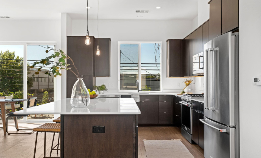 The home chef will love the quartz countertops and sleek stainless KitchenAid appliances including a gas range, microwave, dishwasher, and fridge. 