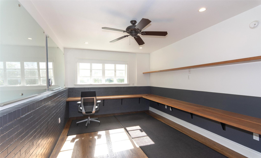 Flex space on main level, could be used as a bedroom or office. Custom built-in walnut  work spaces & floating shelves