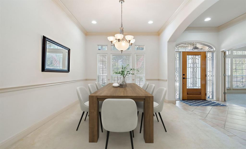 The formal dining room features high ceilings and a large window, creating an inviting and spacious atmosphere for gatherings. Virtually staged.