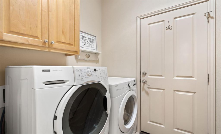 The utility room offers ample cabinet space for convenient storage and organization.