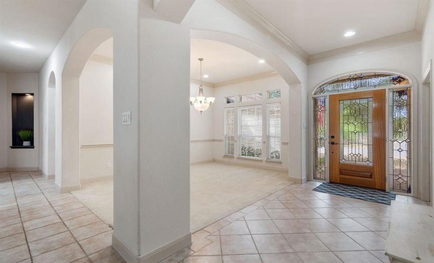 The inviting entryway sets the tone for this home, leading seamlessly into an open floor plan that offers stunning views of the incredible pool.