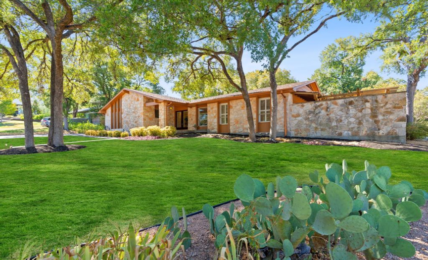 This single story, mid century modern Barton Hills home boasts a beautiful front yard that sits on over a third of an acre. Grass is artificially enhanced ( Photoshop ).