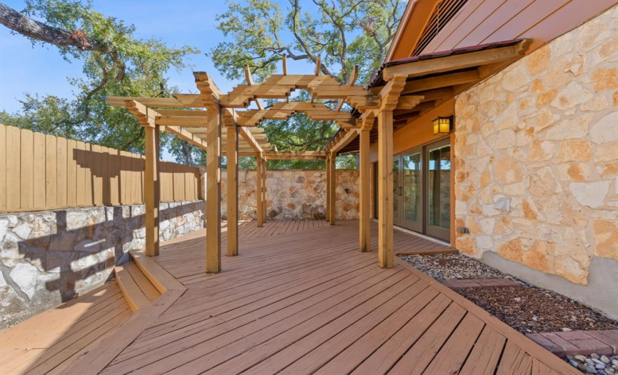 An expansive side deck with a charming pergola, creating the perfect setting for al fresco dining, hosting gatherings, or simply enjoying moments of relaxation under the Texan skies.