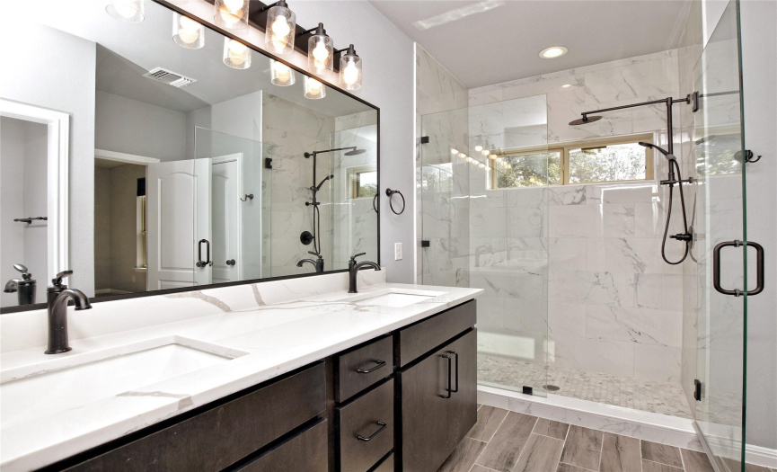 Lovely Primary Bath with dual vanity, updated lighting and fixtures, oversized shower.