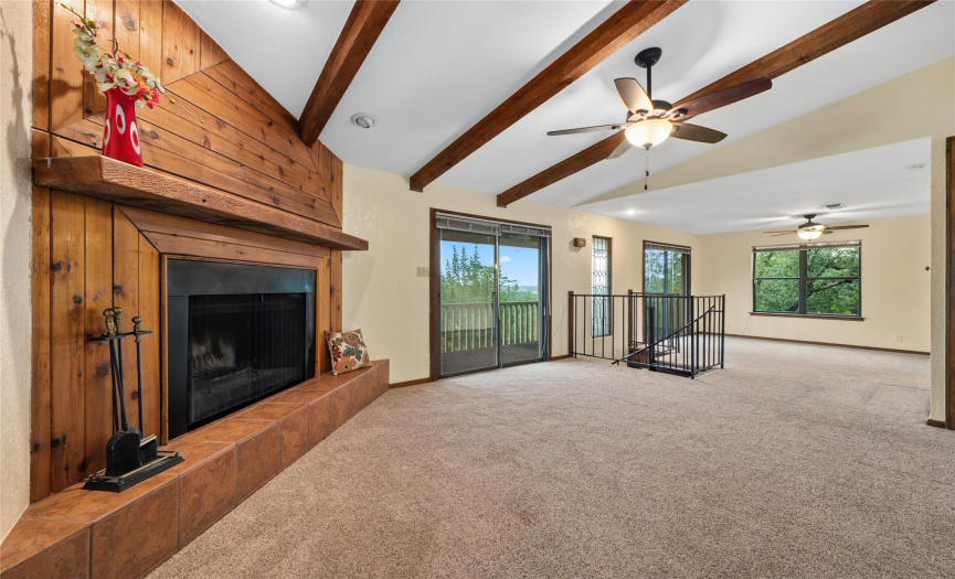 Up the front steps and into the living room with huge wood burning fireplace with wood surround, carpet for cozy moments, etched glass windows custom made, exposed beams, large window seat near the fireplace with 180' views.