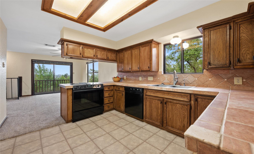 Full kitchen with stone countertops, double sink, new fixtures, window with a view, patio doors off the dining with miles of views, smooth ceiling.