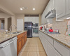 Stainless appliances include a gas cooktop, built-in oven and microwave, and a dishwasher