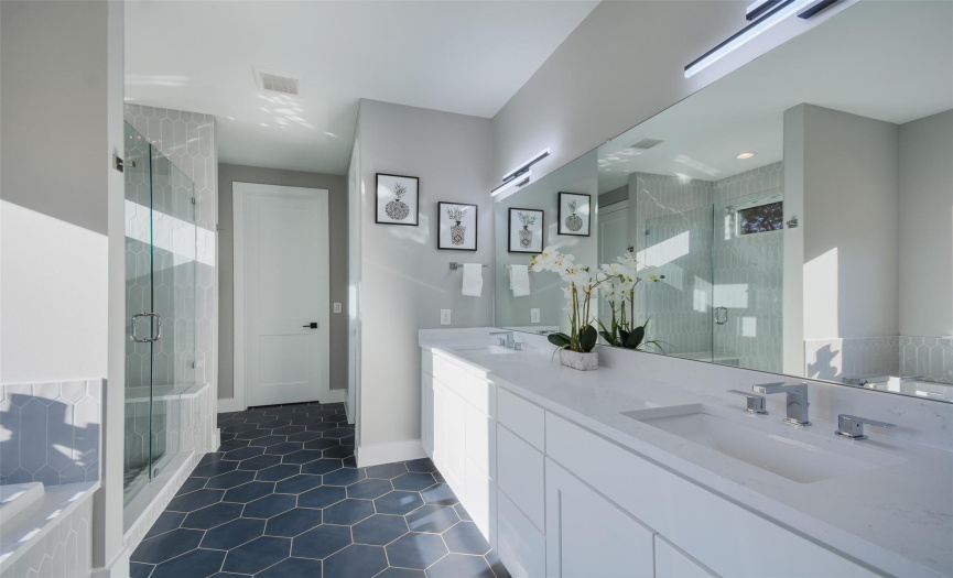 Primary bathroom with quartz counters, dual sinks, soaking tub and walk in tiled shower.