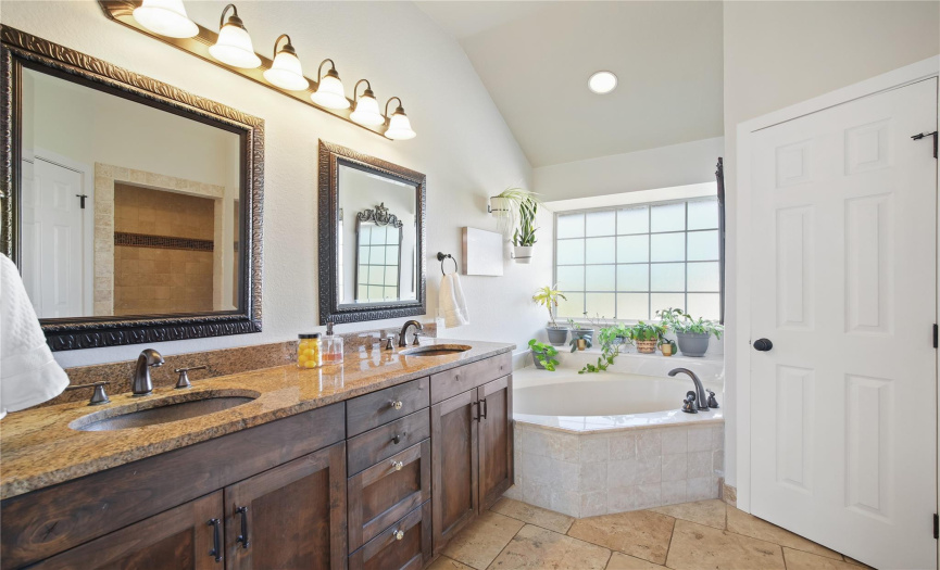 The en-suite bathroom features dual vanities, garden tub, walk in shower and oil-rubbed bronze fixtures.