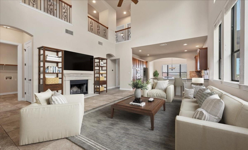 The living room with soaring ceilings is connected to the kitchen (virtually staged).