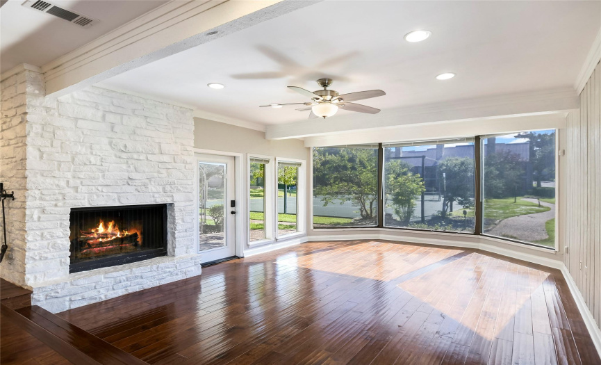 Spacious living room has beautiful stone, wood burning fireplace. Tons of natural light with floor to ceiling windows.
