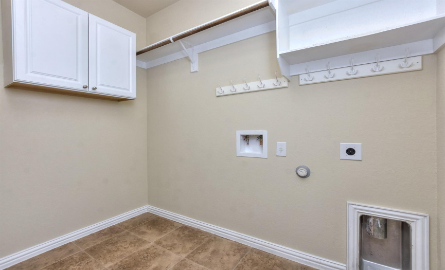 Walk-in laundry room with cabinets and shelves 