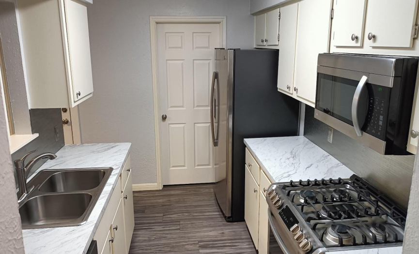 Granite Look Counters Highlighted with Nearly New Appliances Gas Range, Microwave Oven, Dishwasher, Disposal and Refrigerator all in Matching Stanless Steel Finish! 