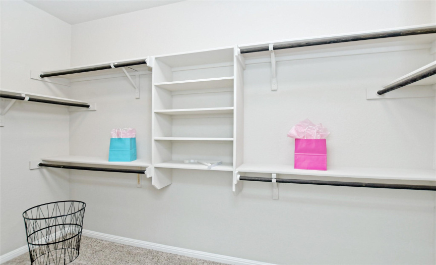 Primary closet has a great layout with plenty of shelf and hanging area.