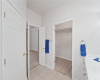 Main bath and walk-in closet with hanging racks and organizer shelving.