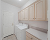 Laundry room with upper cabinets and folding station.