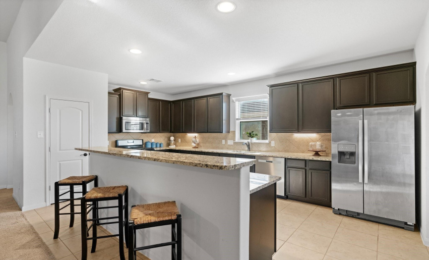 Revel in the contemporary design of the kitchen, showcasing granite countertops and a wealth of stylish cabinetry.