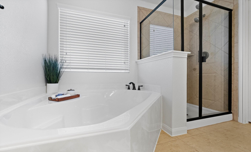The en-suite features a dreamy garden tub and a separate walk-in shower, creating a spa-like retreat.