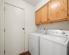 Brightly situated Laundry Room with cabinets to hold all of your utility items.