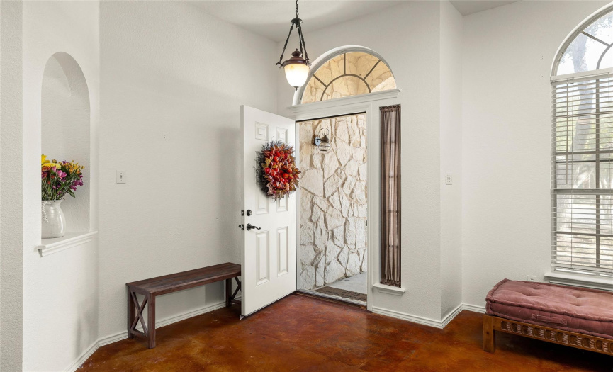 As you open the door you are greeted with an arched alcove ready to display a favorite painting or art motif.