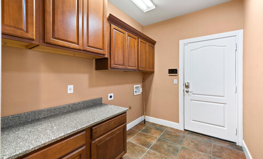 Laundry with an abundance of cabinets, as well as a countertop for folding laundry.