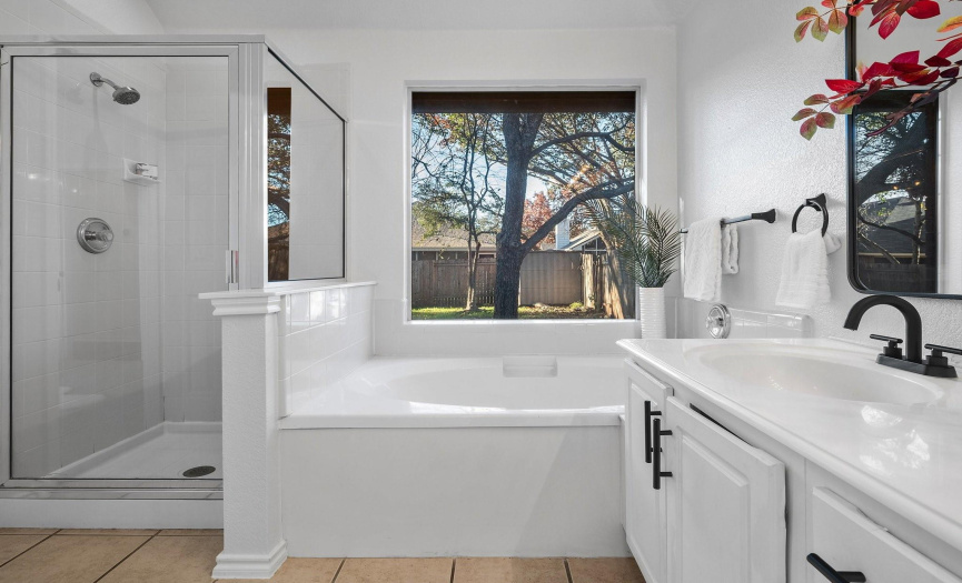 The beautiful ensuite bath boasts a dual vanity, soaking tub, separate shower, and new cabinet hardware and faucets