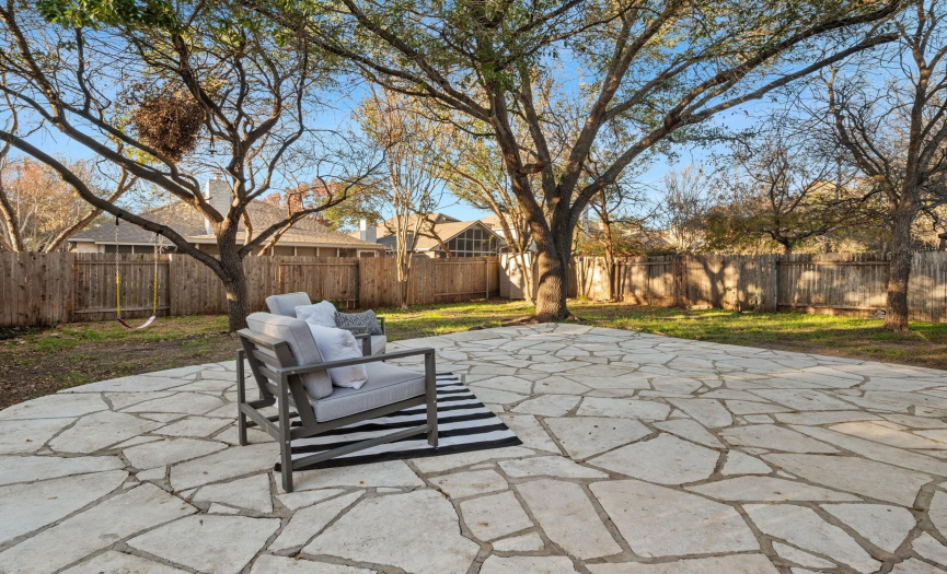 The outdoor space is an extension of the home's appeal with a fully fenced backyard shaded by mature oaks