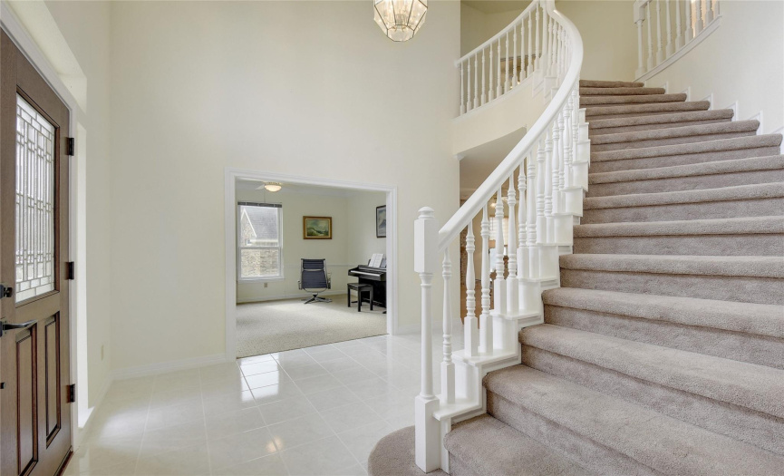 Entry foyer with sweeping stairs, high ceiling, chandelier entry.  To the left formal living, or music room.