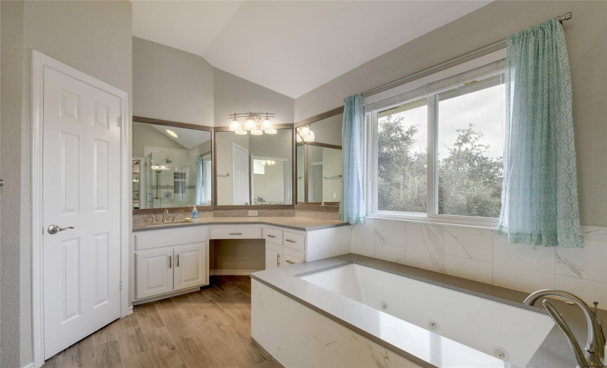 Large soaker tub and two separate sink and counter stations for maximum double occupancy. Window at the large soaker tub, tile flooring.