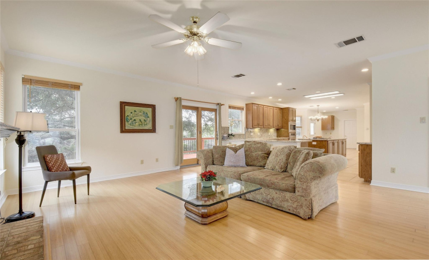 Full view of family room, open area kitchen, ceiling fans, wood flooring, large outdoor deck all in the Eanes school district one block from West Ridge Middle School.