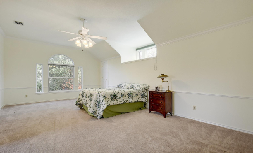 Large primary bedroom with ceiling fan, carpet, large picture window for more light already has an attached shade for lazy sleeping in mornings.