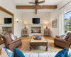 Family living area, custom fireplace, ceiling beams, natural light and view.