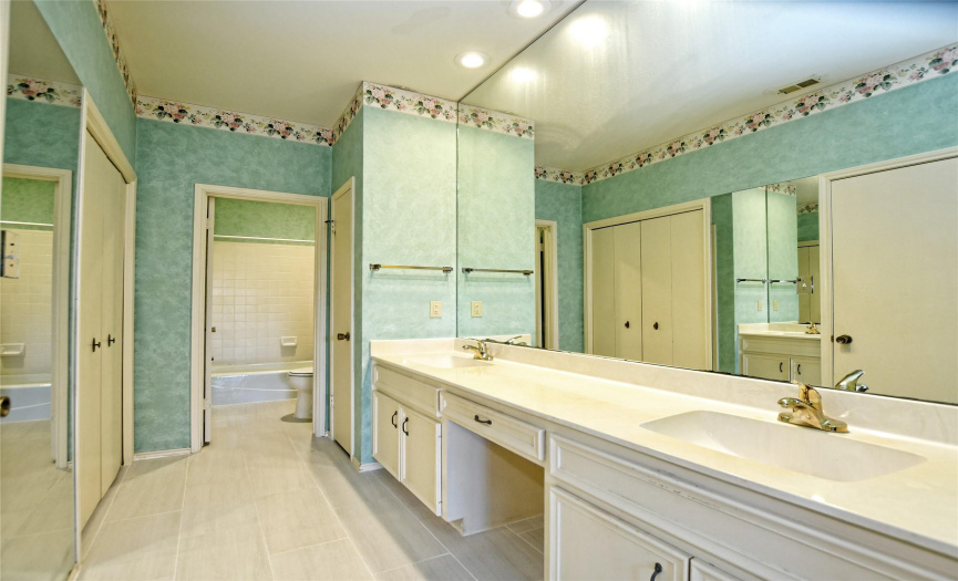 The expansive primary bathroom is light and bright with plenty of closet and linen storage, and ready for your own personal updates.  