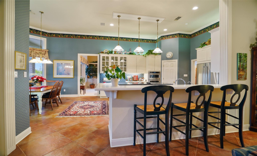This kitchen features a breakfast bar, pantry and casual dining space