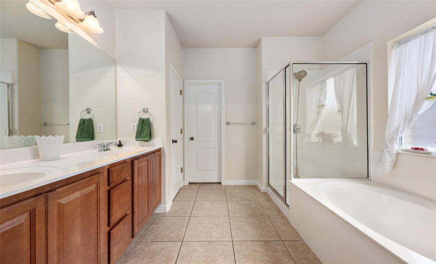The Primary Bathroom boast a double vanity, garden tub, a separate shower, and walk-in closet.