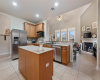 The kitchen features stainless steel appliances, an island, and a stoned accent gas cooktop stove and oven. 