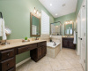 Dual vanities, tile flooring, soaking tub and separate shower in the lovely primary bathroom 
