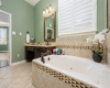 Relaxing soaking tub and window enhanced by plantation shutters.