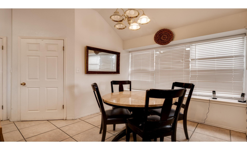 The spacious dining area offers space for a sizable kitchen table and is lined with a wall of windows and a charming windowsill. 