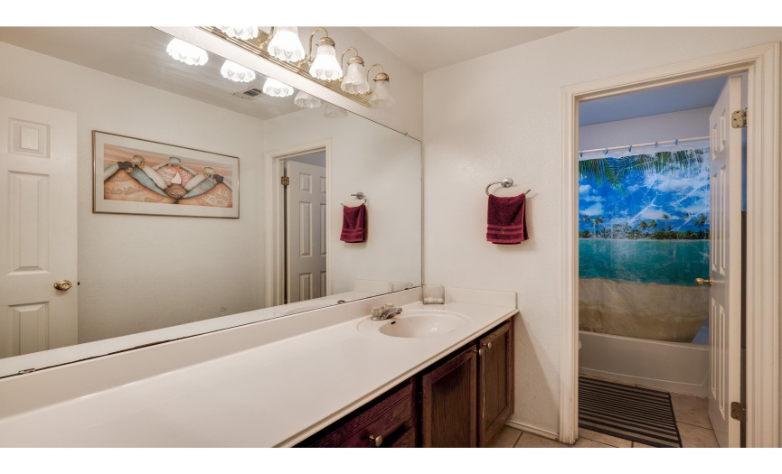 The full secondary bathroom provides a large single vanity and a separate water closet with the commode and shower/tub combo. 